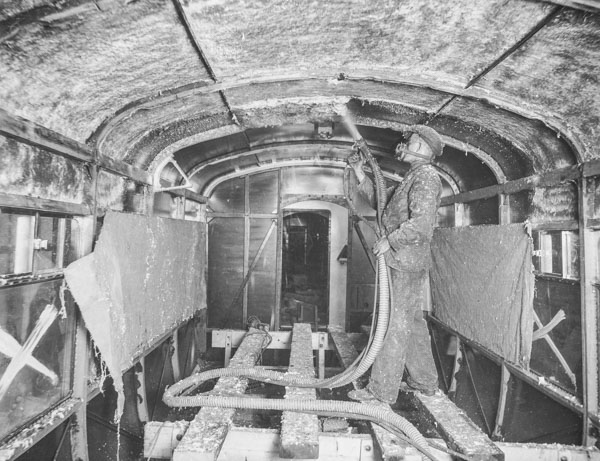 Ausspritzen eines Eisenbahnwagens mit Asbest
