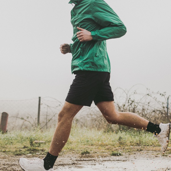 Un uomo fa jogging sotto la pioggia.