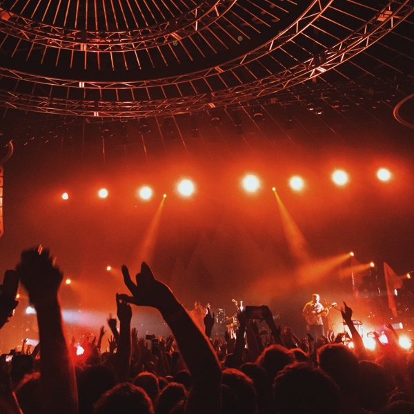 Una folla acclama una band durante un concerto.
